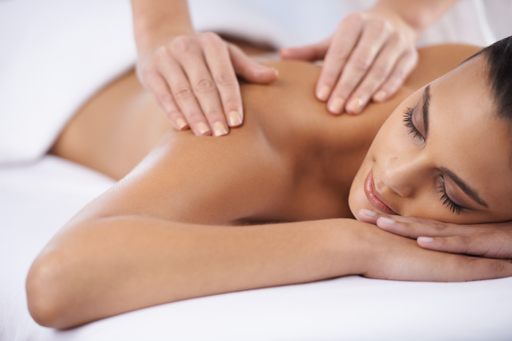 A young woman receiving a massage from a massage professional